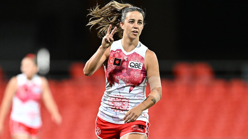 Chloe Molloy raises two fingers to show she had kicked two goals for the Swans in their AFLW elimination final.