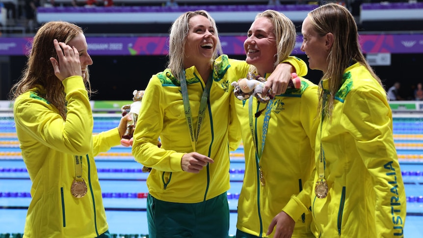 australian swimming relay team smiles and laughs together after being awarded gold medals