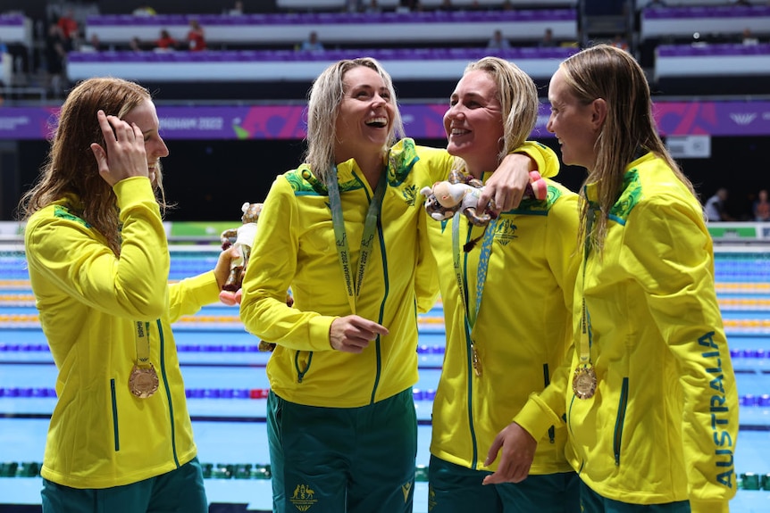 australian swimming relay team smiles and laughs together after being awarded gold medals