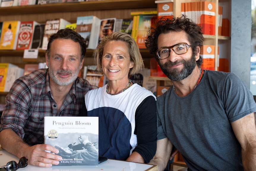 Actor Andrew Lincoln (left) holding a book while sitting alongside with Sam Bloom (centre) and Cameron Bloom.