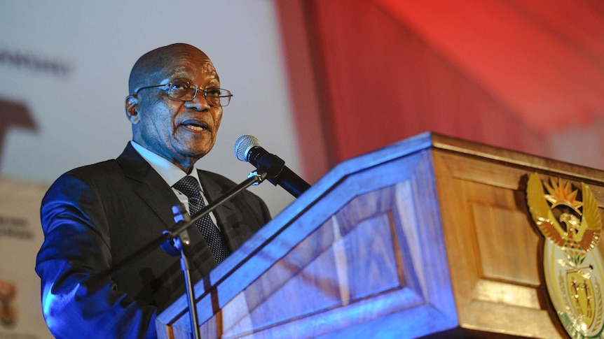 South African President Jacob Zuma speaks at a lectern.