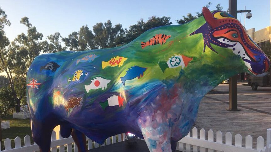 Cow sculpture painted with fish designs showing flags of the world, but with Taiwan flag painted over in blue by council.