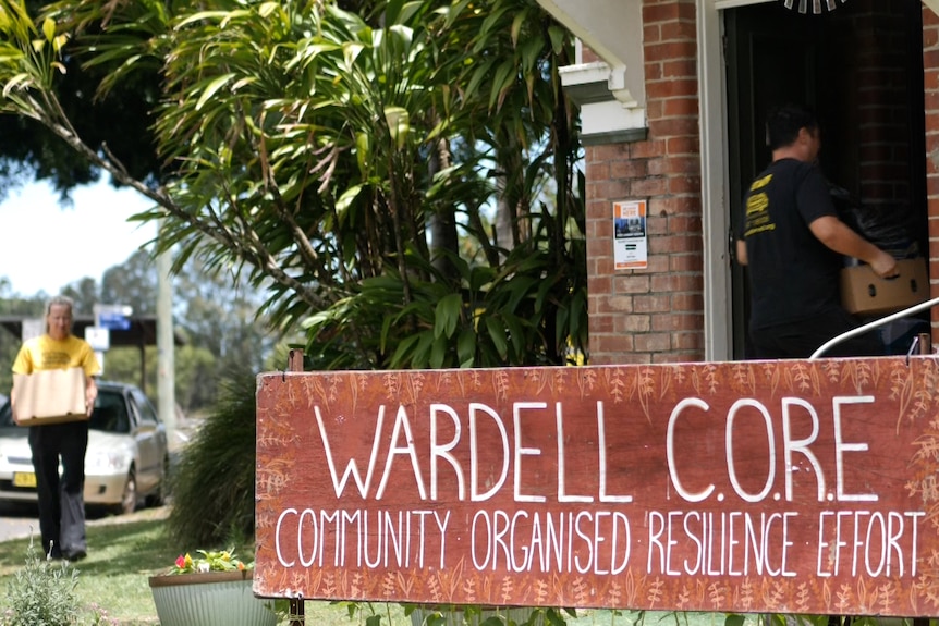 People carrying boxes into a brick building with a sign saying 'Wardell Core'