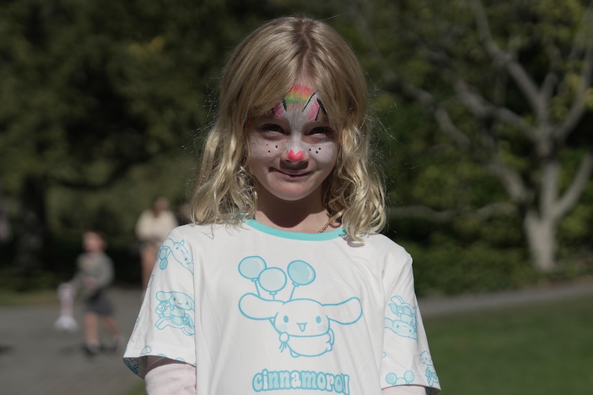 A girl with Easter bunny face paint.