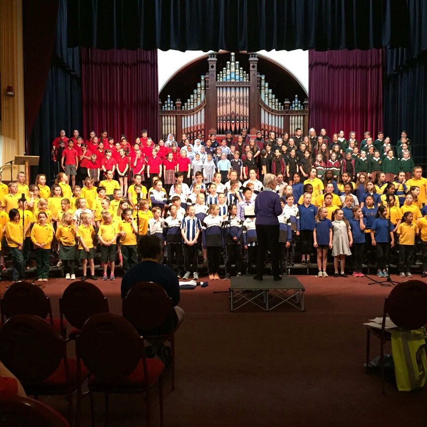 various school choirs from around Launceston rehearsing in the Albert Hall  in front of a conductor