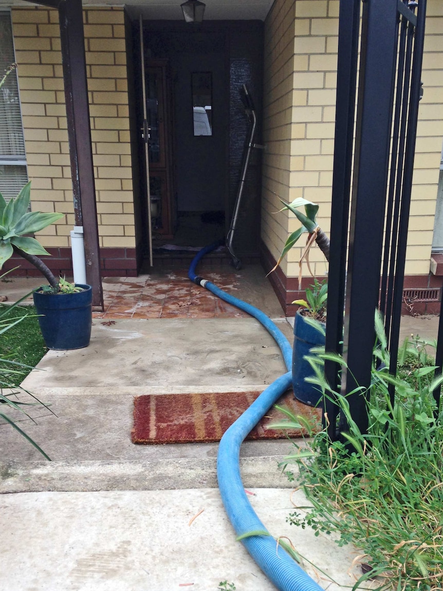 A burst main flooded houses at Valley View in Adelaide, requiring pumping to remove the water.