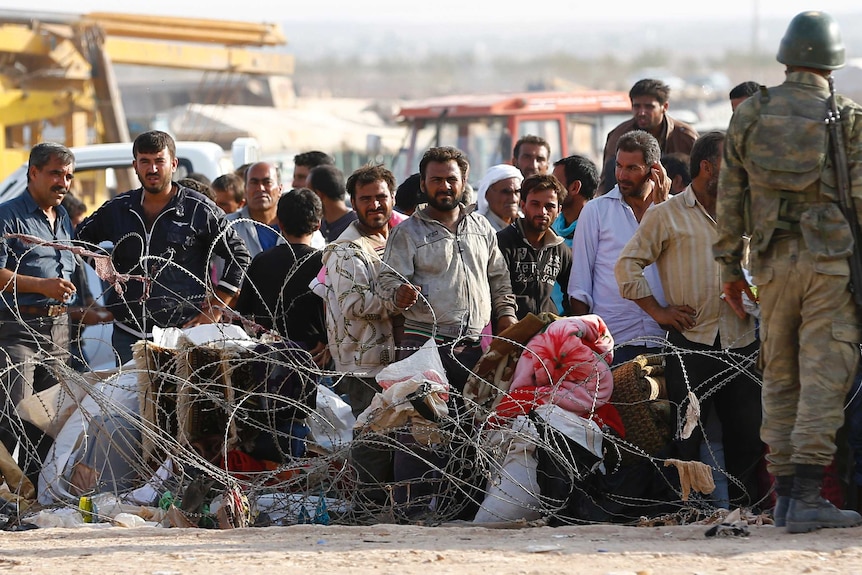 Syrian Kurds wait to cross into Turkey