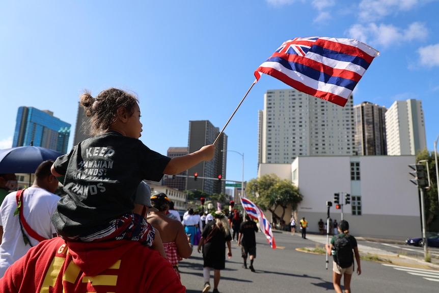 A girl with a Hawaiian flag.