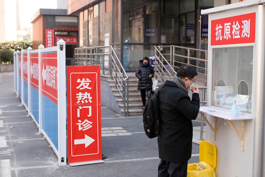 A man tests himself for the coronavirus disease outside the fever clinic of a hospital in Shanghai