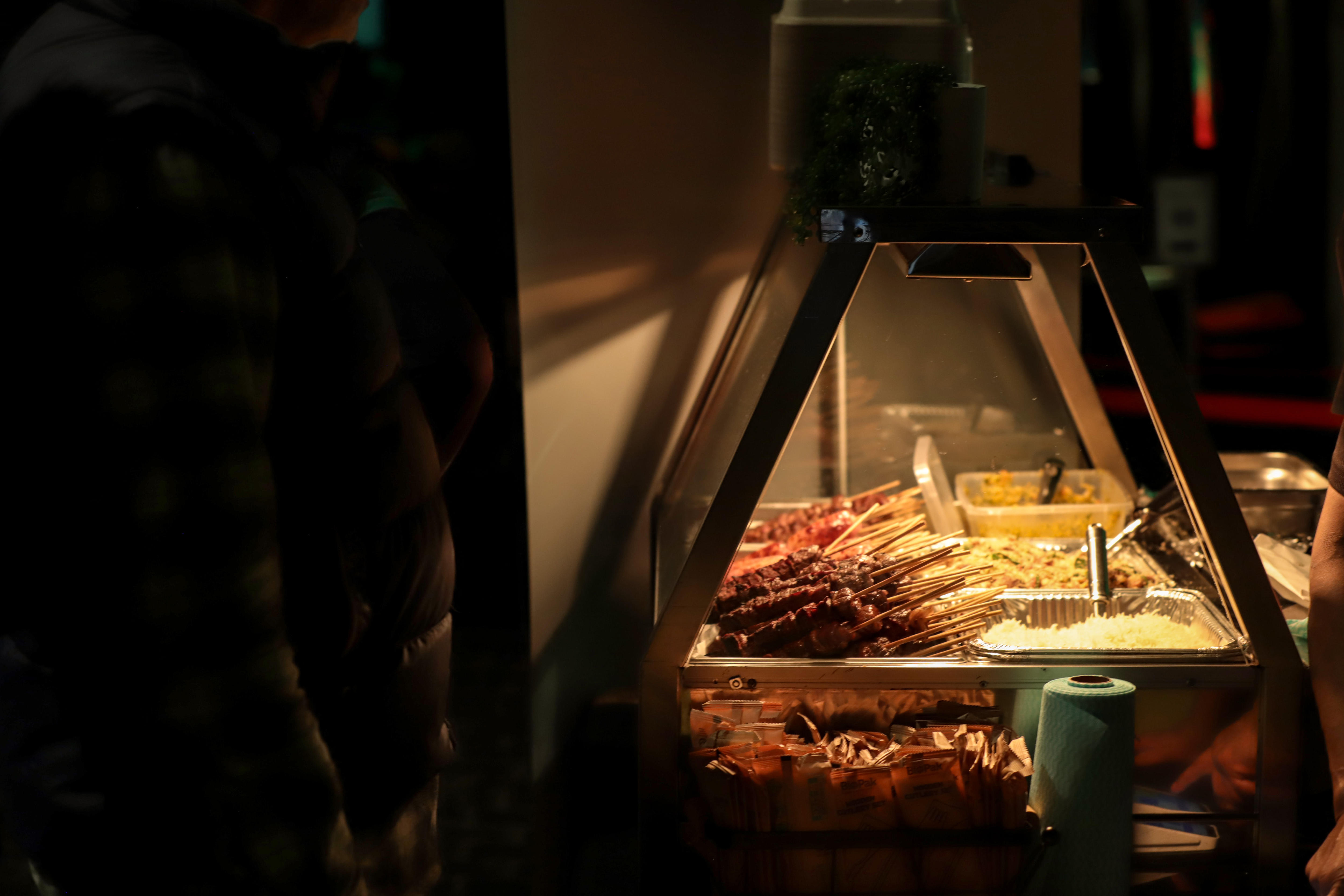 A bain maire with rows of different meat skewers under a warming light