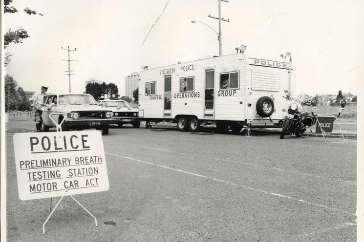 A black and white photo of a caravan and police sign