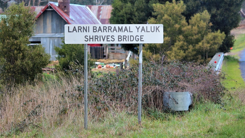 A sign reads Larni Barramal Yaluk Shrives Bridge with trees and shrubs behind 