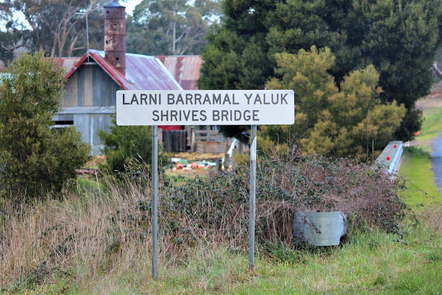 A sign reads Larni Barramal Yaluk Shrives Bridge with trees and shrubs behind 
