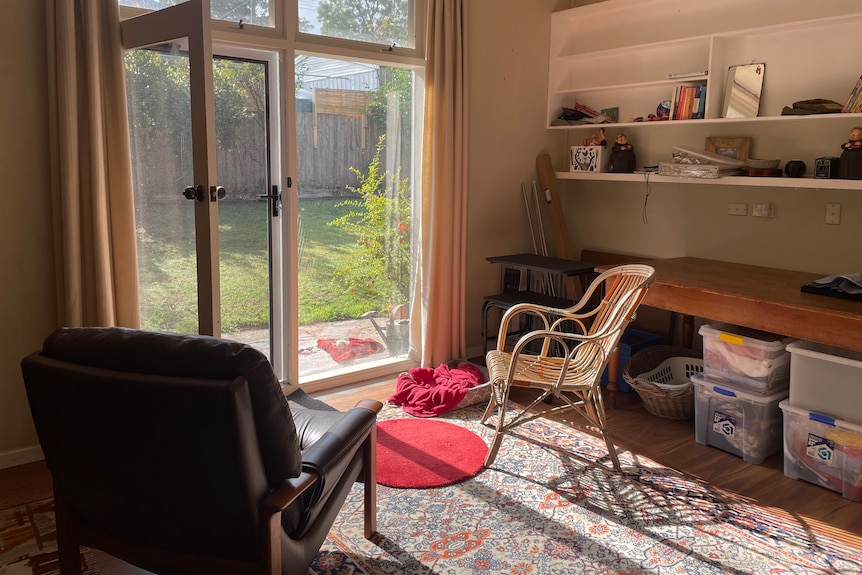 Light streams into a living area through a glass window and door 