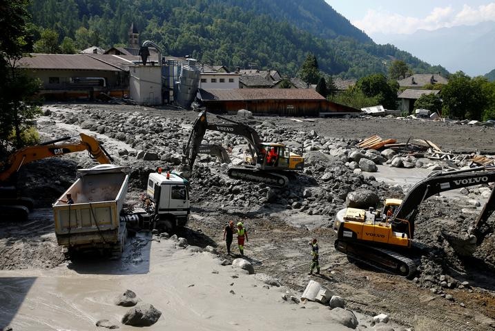 Excavators remove the debris from a landslide in Bondo
