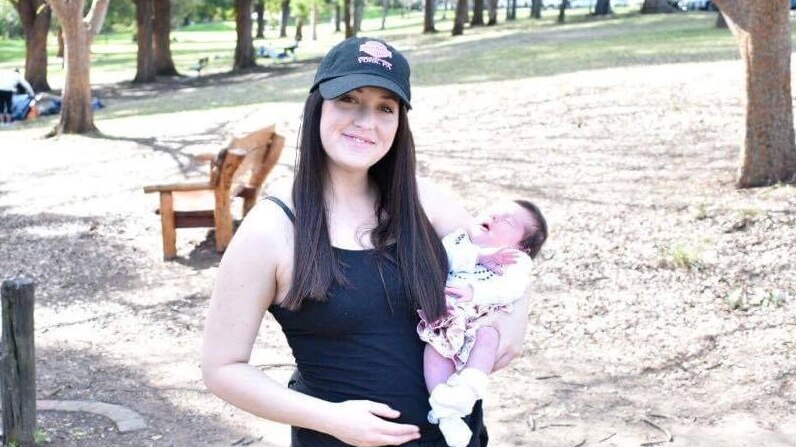 Kathryn Price holds baby Lily in the park