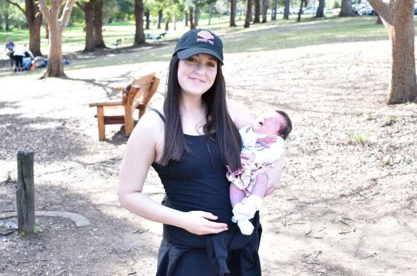 Kathryn Price holds baby Lily in the park