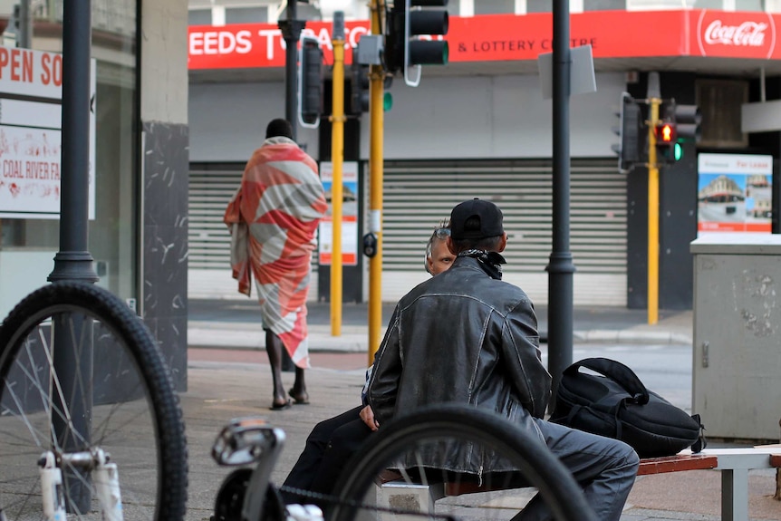 People on the street with a bike in the foreground.