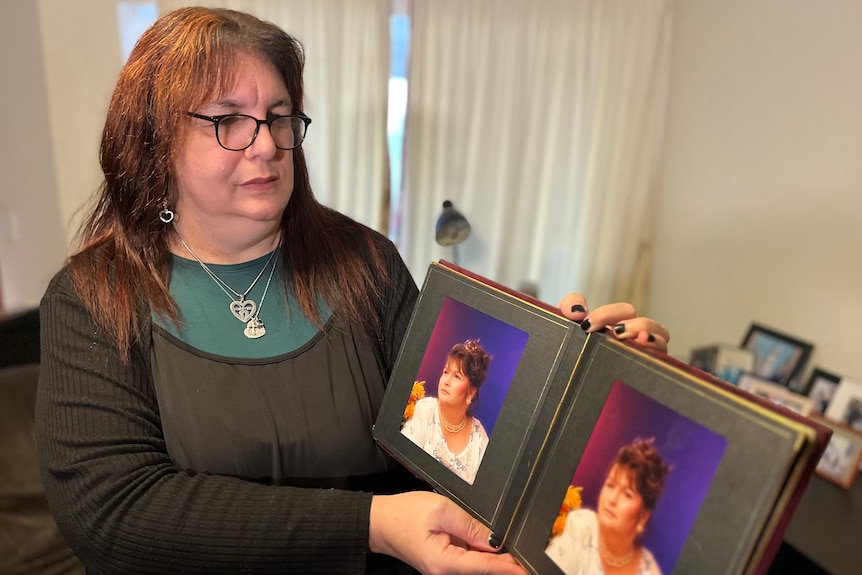 Ruth Taylor looks at a photo album containing photos of her mother at a younger age