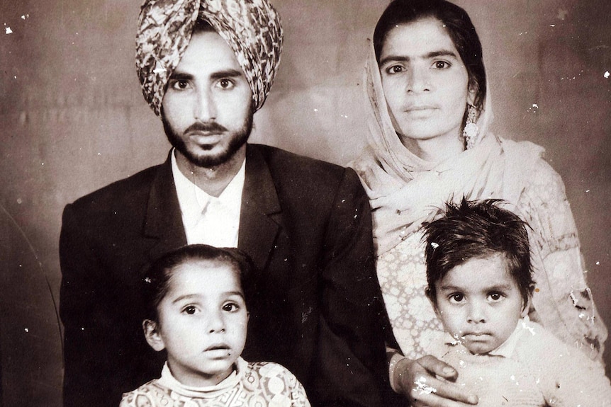 A sepia photo shows a young Mintu with his parents and sibling, in traditional Sikh clothing.