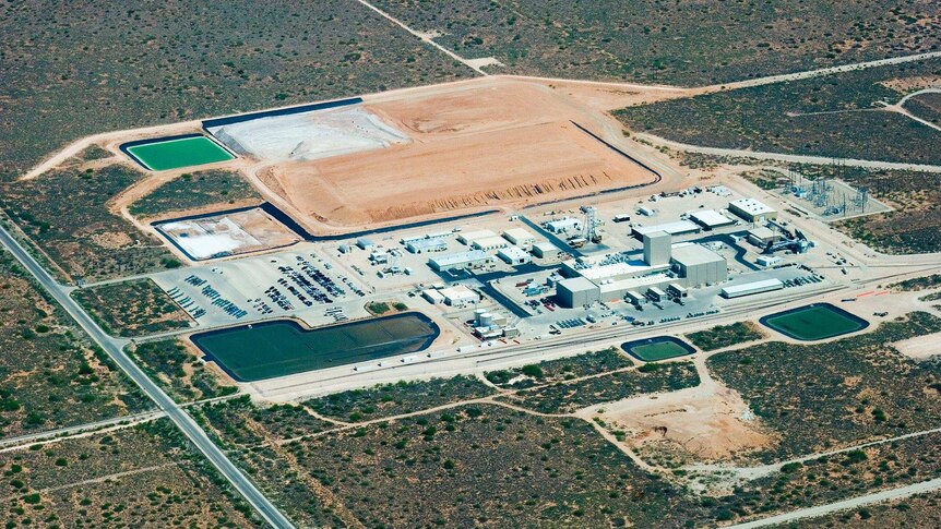 An aerial shot of the WIPP nuclear waste dump, it looks a little like a mine with dirt ridges and pools.