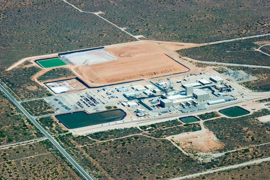 An aerial shot of the WIPP nuclear waste dump, it looks a little like a mine with dirt ridges and pools.