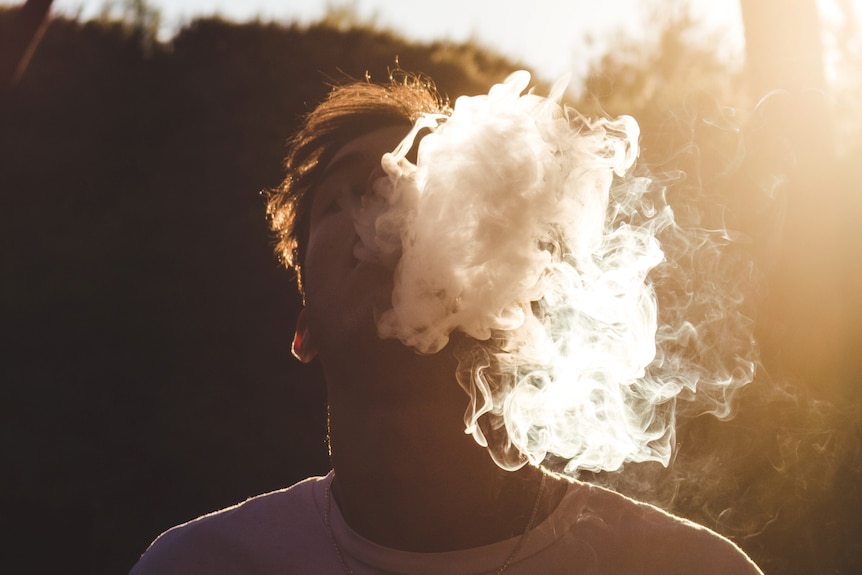 young person with smoke coming out of their mouth after vaping 