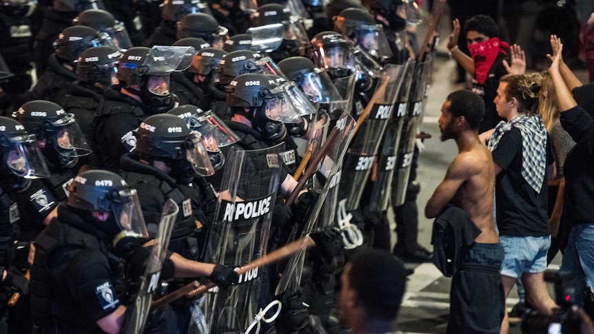 Police in riot gear approach demonstrators