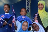 Six children waving Australian flags celebrate together at the largest Australia Day citizenship ceremony in Wanneroo.