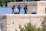 Police SWAT officers surround the Sikh Temple of Wisconsin.