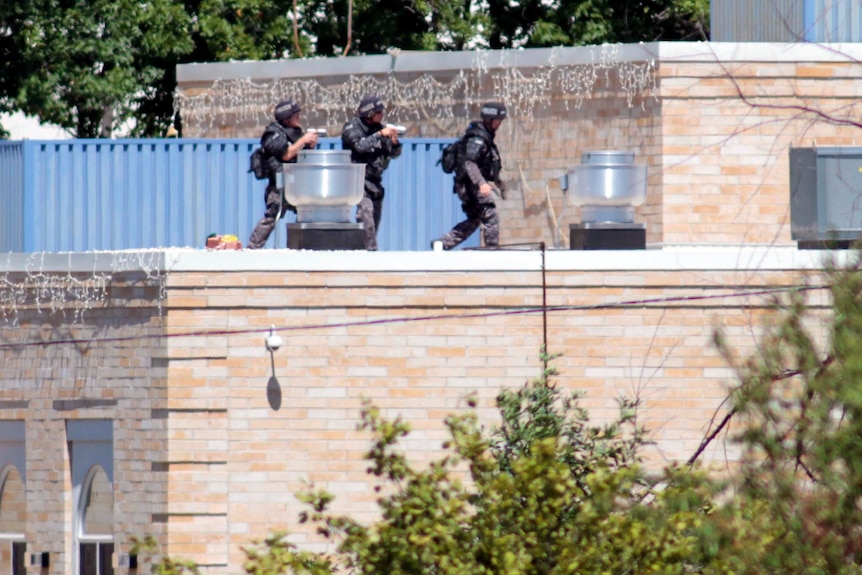 Police SWAT officers surround the Sikh Temple of Wisconsin.