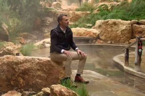Peninsula Hot Springs CEO Craig Mitchell sits in front of one of his company's outdoor thermal baths.