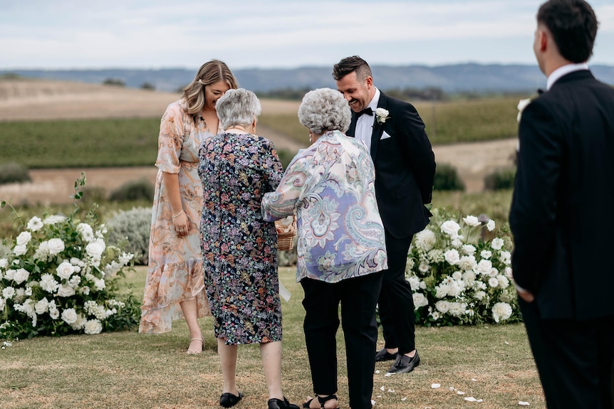 Two grandmothers spread flowers at a wedding.