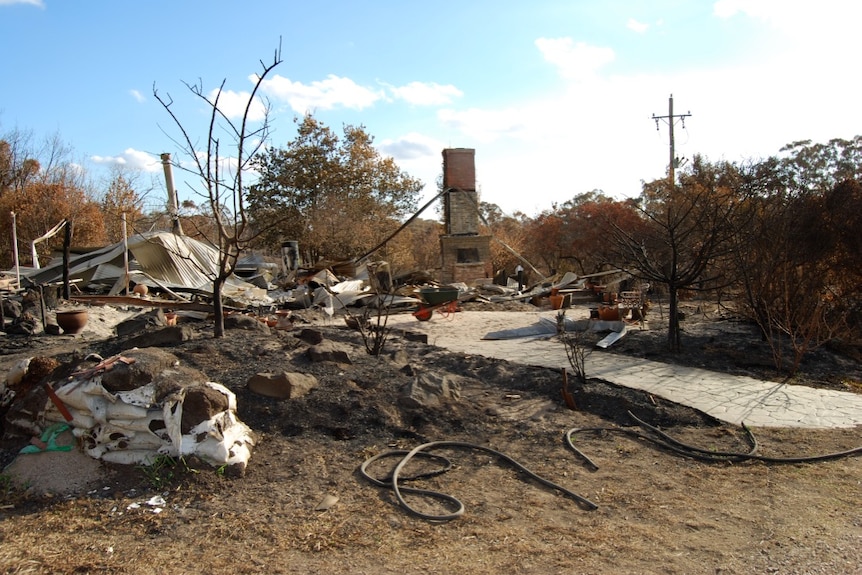Les restes d'une maison détruite par un incendie, dont une cheminée en brique