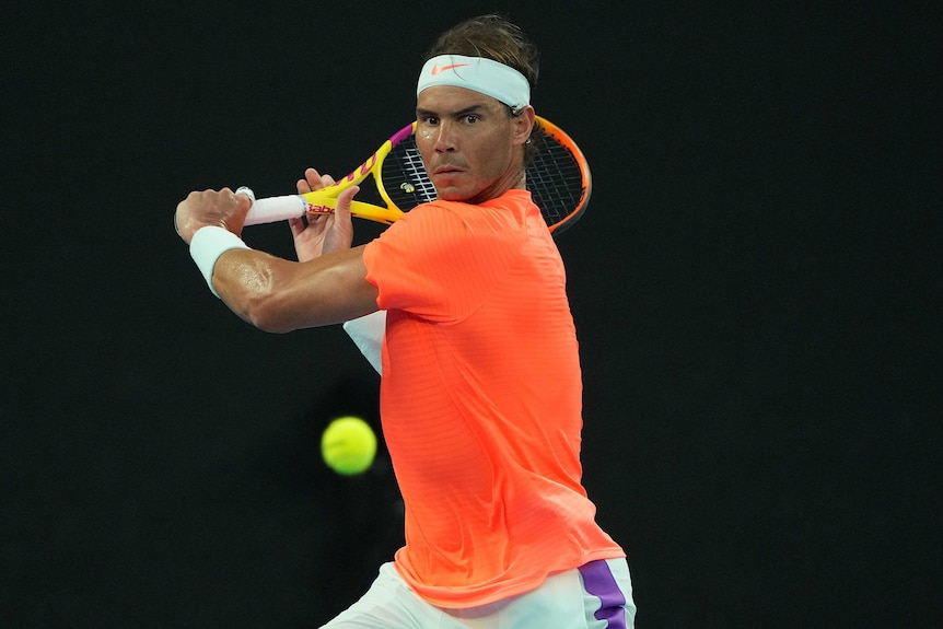 Rafael Nadal is preparing to hit a backhand against Stefanos Tsitsipas at the Australian Open.