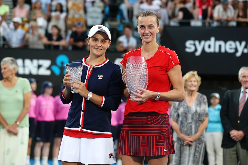 Winner Petra Kvitova and runner-up Ash Barty hold trophies after the Sydney International final.