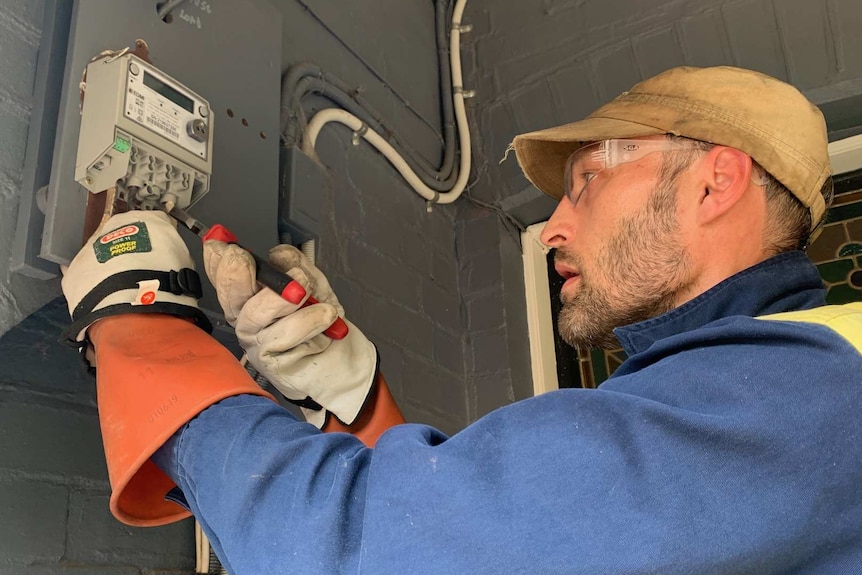 An electrician installs a new smart meter at a house in Sydney's inner-west.