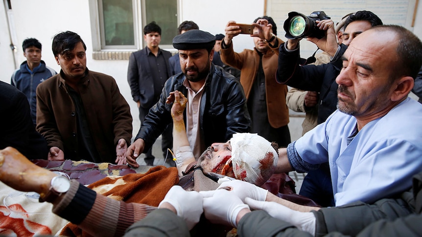 An injured man is moved into an ambulance after a suicide attack in Kabul.