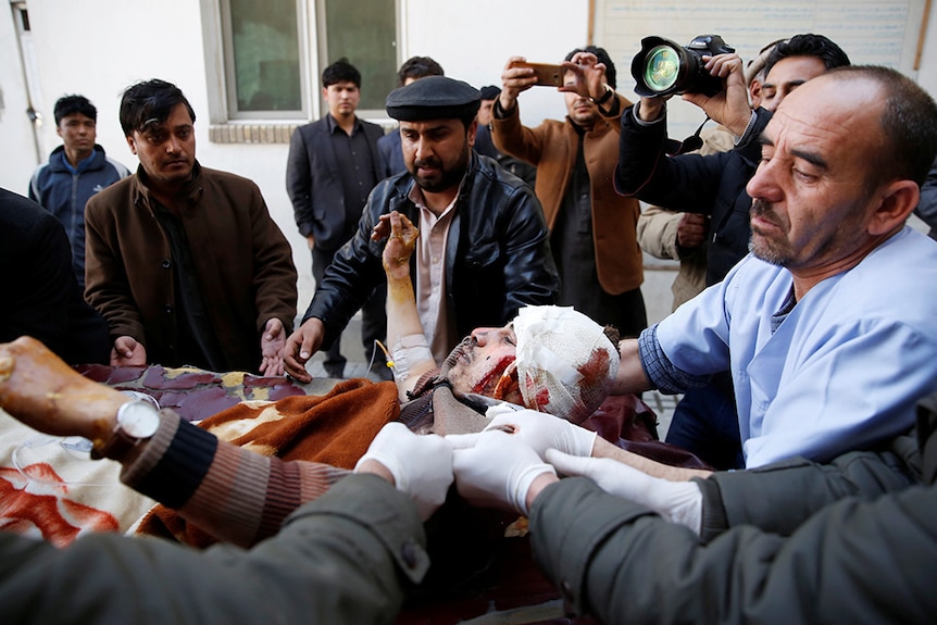 An injured man is moved into an ambulance after a suicide attack in Kabul.