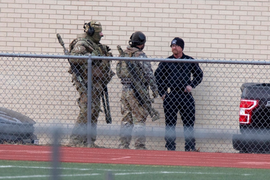 two army soldiers with a a police office