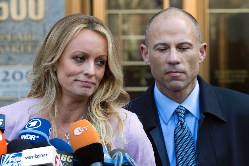 Adult film actress Stormy Daniels stands with her lawyer Michael Avenatti