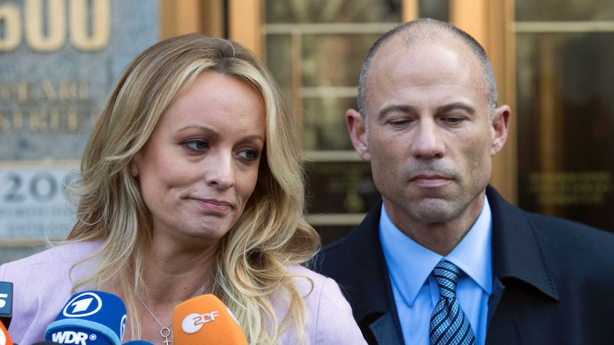 Adult film actress Stormy Daniels stands with her lawyer Michael Avenatti