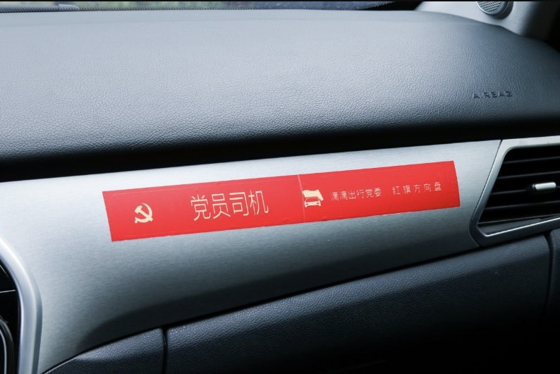A red dashboard sticker reads "party member driver" in Chinese.
