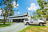 A large white veterinary building with a ute in front of it