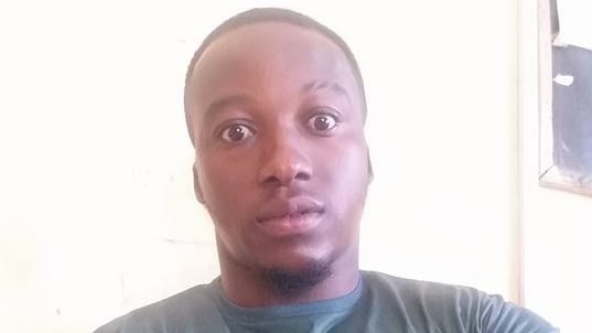 Ghanaian teacher Richard Appiah Akoto poses for a selfie wearing a green shirt.