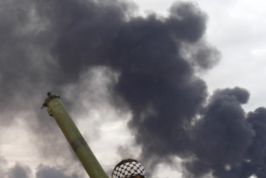 A rebel holds a rocket propelled grenade launcher during clashes with pro-Gaddafi forces