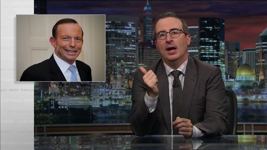 Comedian John Oliver points at a picture of Tony Abbott.