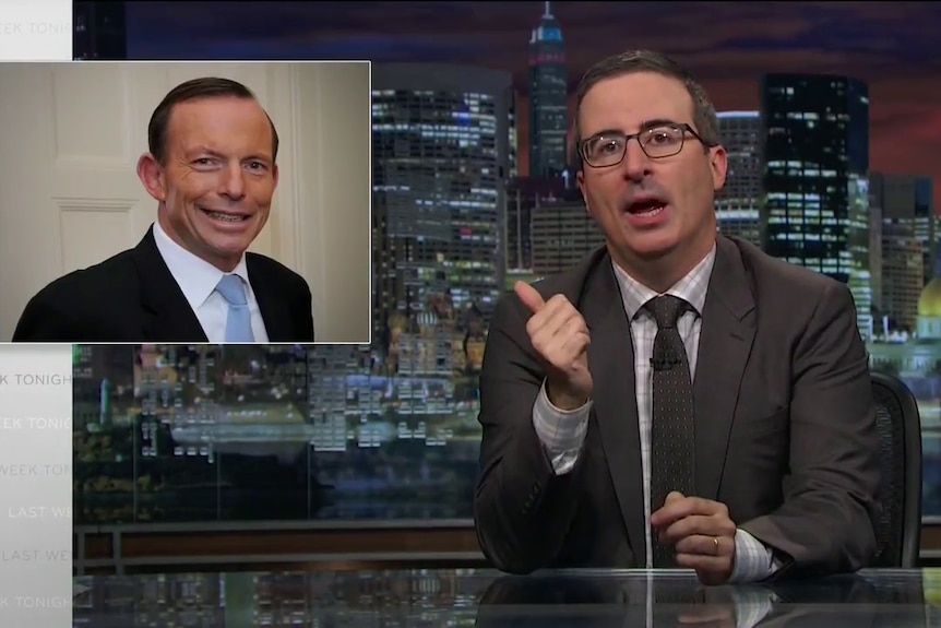 Comedian John Oliver points at a picture of Tony Abbott.