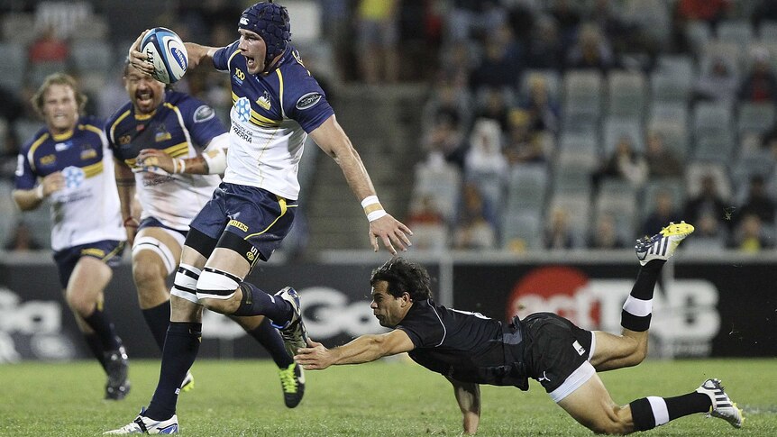 Underdogs bite ... the Brumbies' Ben Mowen fends off a tackle in Canberra.