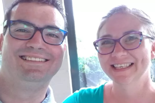 A couple smiling in a selfie - both wearing glasses